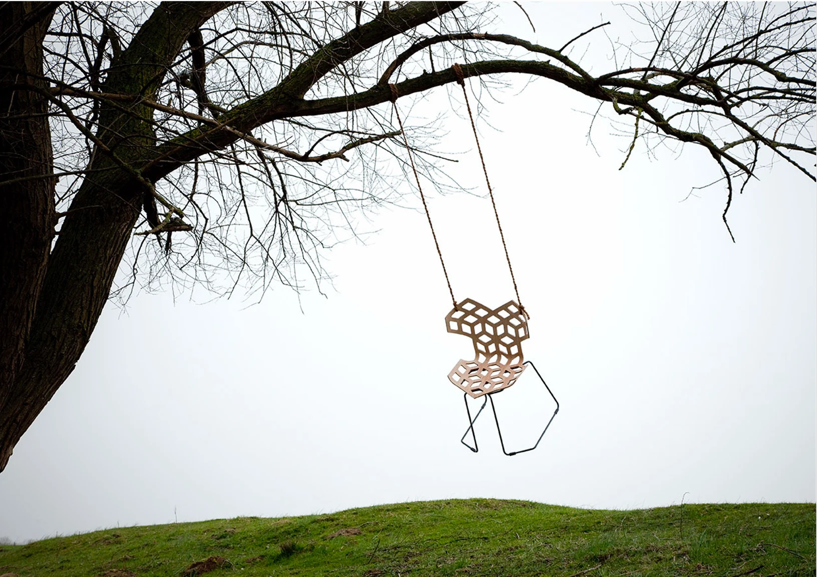 Skitsch — geometric chair suspended from a tree